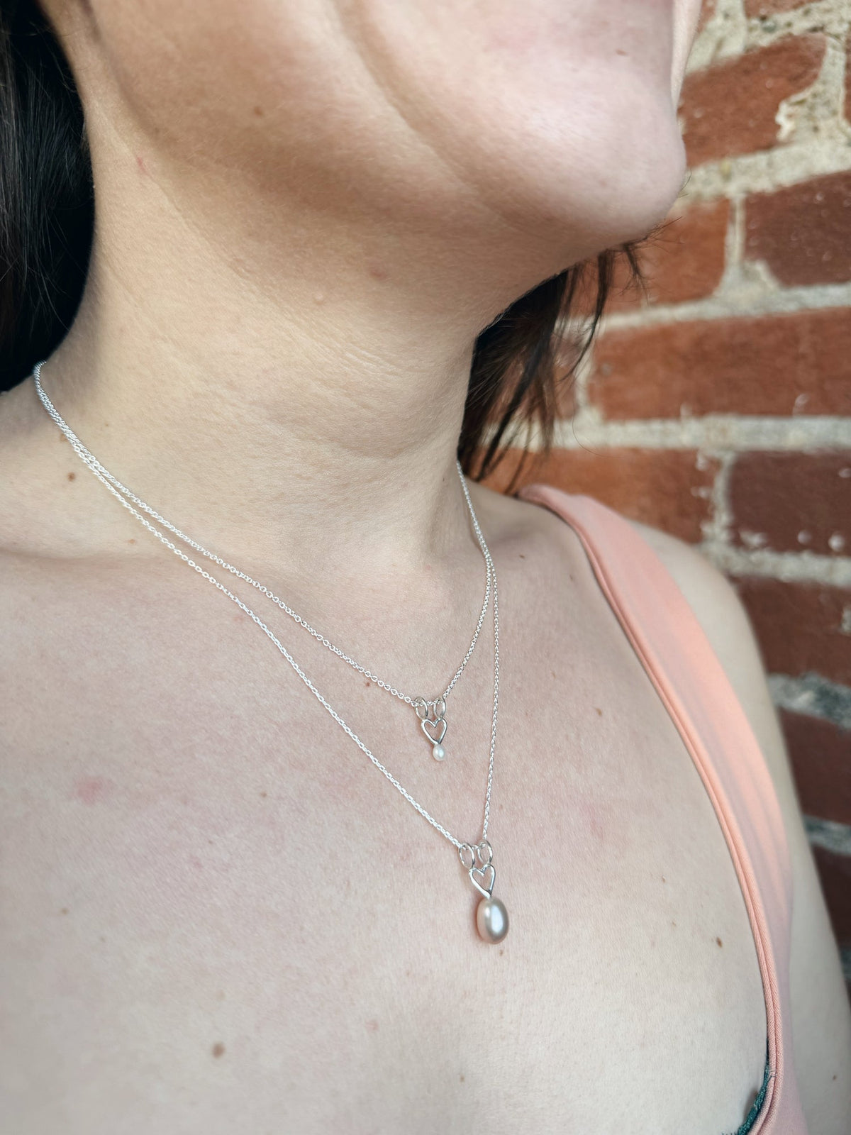 Necklace with heart charm and small white pearl