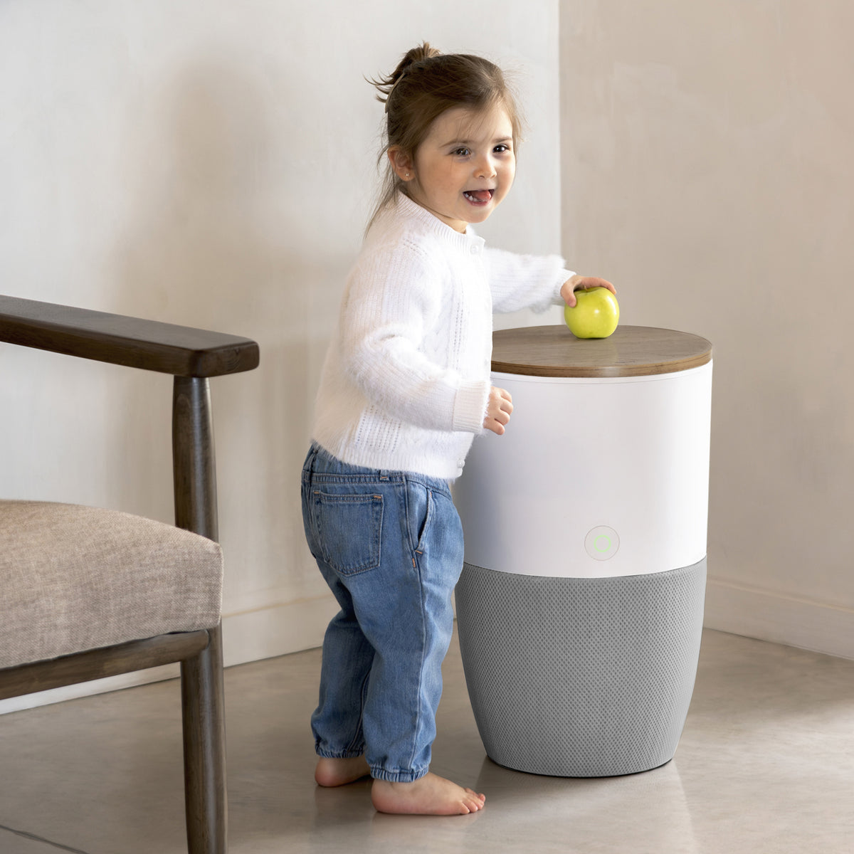 Child placing a ball on the walnut top of the Bloom air purifier